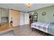 Bedroom with green walls, hardwood floors, bed, ladder bookshelf, and barn door at 6979 Weasel Way, Evergreen, CO 80439