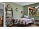 Bedroom with green walls, hardwood floors, bed, ladder bookshelf, and a picturesque view from the window at 6979 Weasel Way, Evergreen, CO 80439