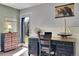 Bedroom with green and grey walls, hardwood floors, desk, and mountain views through a glass door at 6979 Weasel Way, Evergreen, CO 80439