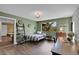 Bedroom with green walls, hardwood floors, bed, desk, and a picturesque view from the window at 6979 Weasel Way, Evergreen, CO 80439