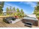 Outdoor deck with hot tub, lounge furniture, fire table, umbrella, and beautiful treed mountain views at 6979 Weasel Way, Evergreen, CO 80439