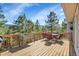 Spacious deck with outdoor dining area and scenic views of trees and mountains at 6979 Weasel Way, Evergreen, CO 80439