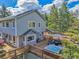 Exterior shot showing a multi-story home with a large deck, hot tub, and outdoor seating area at 6979 Weasel Way, Evergreen, CO 80439