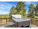 Outdoor hot tub on a wooden deck with scenic mountain and forest views at 6979 Weasel Way, Evergreen, CO 80439