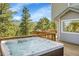 Outdoor hot tub is located on a deck with forest and mountain views at 6979 Weasel Way, Evergreen, CO 80439