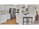 Bright kitchen with white cabinets, stainless appliances, breakfast bar and hardwood floors at 6979 Weasel Way, Evergreen, CO 80439