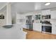 Spacious kitchen with white cabinets, stainless steel appliances and hardwood flooring at 6979 Weasel Way, Evergreen, CO 80439