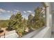 Picturesque view from a window featuring a spa and lush green trees at 6979 Weasel Way, Evergreen, CO 80439