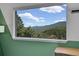 Scenic mountain view from a bright window with green trim in bedroom at 6979 Weasel Way, Evergreen, CO 80439
