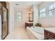 Bright bathroom features a soaking tub, glass enclosed shower, and dark wood vanity at 10631 Autumnsong Ct, Highlands Ranch, CO 80126