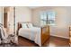 Cozy bedroom with wood floors, shuttered windows, and a wooden-framed bed, creating a warm and inviting space at 10631 Autumnsong Ct, Highlands Ranch, CO 80126