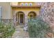 Inviting covered front porch with stone pillars and an arched entryway at 10631 Autumnsong Ct, Highlands Ranch, CO 80126