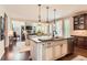 Island kitchen boasts granite counters, white cabinets, and pendant lighting, open to the living area at 10631 Autumnsong Ct, Highlands Ranch, CO 80126