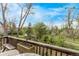 Outdoor deck with seating overlooking a lush backyard with mature trees and blooming spring foliage at 683 Sunnyside St, Louisville, CO 80027