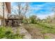 Scenic view of the backyard with a deck overlooking a well-manicured lawn and a variety of trees at 683 Sunnyside St, Louisville, CO 80027