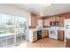 Kitchen with wood cabinets, white appliances, and adjacent sliding glass door to a outdoor deck at 683 Sunnyside St, Louisville, CO 80027