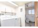 Bright laundry room featuring a washer, dryer, built-in shelving, and access to an adjacent bathroom at 683 Sunnyside St, Louisville, CO 80027