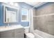 Bright bathroom features a modern vanity, blue walls, and tiled shower-tub combo at 16277 Blueleaf Pl, Parker, CO 80134