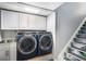 Convenient laundry area with modern washer and dryer, plus storage cabinets and sink at 16277 Blueleaf Pl, Parker, CO 80134