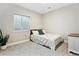 Simple bedroom featuring a comfortable bed, a large window, and a small dresser at 8102 S Adams Fork Ave, Littleton, CO 80125