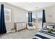 Inviting bedroom with a bright window, comfortable beanbag chair, and a cozy bed with striped bedding at 8102 S Adams Fork Ave, Littleton, CO 80125
