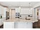 Bright kitchen with a large island, stainless steel appliances, white cabinets, and backsplash at 8102 S Adams Fork Ave, Littleton, CO 80125