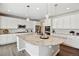 Well-equipped kitchen with white cabinets, a large granite island, stainless steel appliances, and pendant lights at 8102 S Adams Fork Ave, Littleton, CO 80125