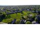 An aerial view of the neighborhood showcasing the well-maintained homes, a green field and tree-lined streets at 12652 Glencoe St, Thornton, CO 80241