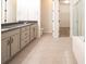 Bathroom featuring tiled floors, dual vanity, shower, toilet, and access to walk-in closet at 12652 Glencoe St, Thornton, CO 80241