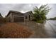 Traditional home featuring a two-car garage, stone accents and low maintenance landscaping on a wet, overcast day at 12652 Glencoe St, Thornton, CO 80241