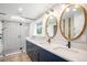 Stylish bathroom with dual sinks, quartz countertop, and glass enclosed shower at 10482 W 75Th Ave, Arvada, CO 80005