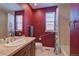 Bathroom with shower/tub combo, vanity, and red walls at 8588 W Quarles Pl, Littleton, CO 80128