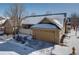 Tan two-story home with attached garage and snow-covered front yard at 8588 W Quarles Pl, Littleton, CO 80128