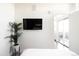 Bright bedroom features minimalist decor, a mounted TV, and access to outdoor balcony at 2880 Zuni St # 406, Denver, CO 80211