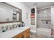Bathroom with wooden vanity and marble countertop, featuring a framed mirror and tile backsplash, tub and toilet at 7923 S Marion Ct, Centennial, CO 80122