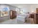 Well-lit bedroom featuring large windows, neutral carpet, dresser, and a comfortable bed with decorative pillows at 7923 S Marion Ct, Centennial, CO 80122
