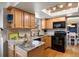 Well-lit kitchen featuring granite countertops, wood cabinets, modern appliances, and a skylight at 7923 S Marion Ct, Centennial, CO 80122
