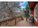 Relaxing wooden back deck featuring a natural wooded setting and grill at 13339 E Idaho Pl, Aurora, CO 80012