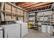 Basement laundry area with washer, dryer, shelving, and storage containers at 13339 E Idaho Pl, Aurora, CO 80012