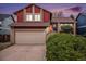 Two-story home featuring red wood siding and a brick-accented garage with manicured landscaping at 13339 E Idaho Pl, Aurora, CO 80012