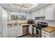 Cozy kitchen with white cabinets, wood-look countertops, and stainless steel appliances at 13339 E Idaho Pl, Aurora, CO 80012