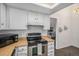 Compact kitchen with white cabinets, wood-look countertops, and stainless steel appliances at 13339 E Idaho Pl, Aurora, CO 80012