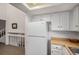 Bright kitchen with white cabinets, wood countertops, and a white refrigerator at 13339 E Idaho Pl, Aurora, CO 80012