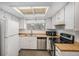 Cozy kitchen with white cabinets, wood-look countertops, and stainless steel appliances at 13339 E Idaho Pl, Aurora, CO 80012