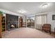 Carpeted living room with a large stone fireplace, bookshelves, a sliding door and chairs at 13339 E Idaho Pl, Aurora, CO 80012