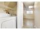 Bright laundry area with white washer and dryer, wire shelving, and durable tile flooring at 5711 W 92Nd Ave # 30, Westminster, CO 80031