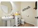 Cozy powder room with pedestal sink, toilet, cabinet, and decorative wall art, with tile flooring at 4944 W 107Th Loop, Westminster, CO 80031