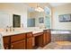 Bright bathroom featuring a jacuzzi tub, double sinks with white countertops, and vanity with storage at 4944 W 107Th Loop, Westminster, CO 80031