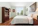 Cozy bedroom with hardwood floors, built-in bookcase, and a large window overlooking the lush greenery at 4944 W 107Th Loop, Westminster, CO 80031