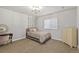 A simple bedroom with a queen-size bed, large window, and vanity area provides a comfortable and stylish setting at 444 Pasada Way, Monument, CO 80132